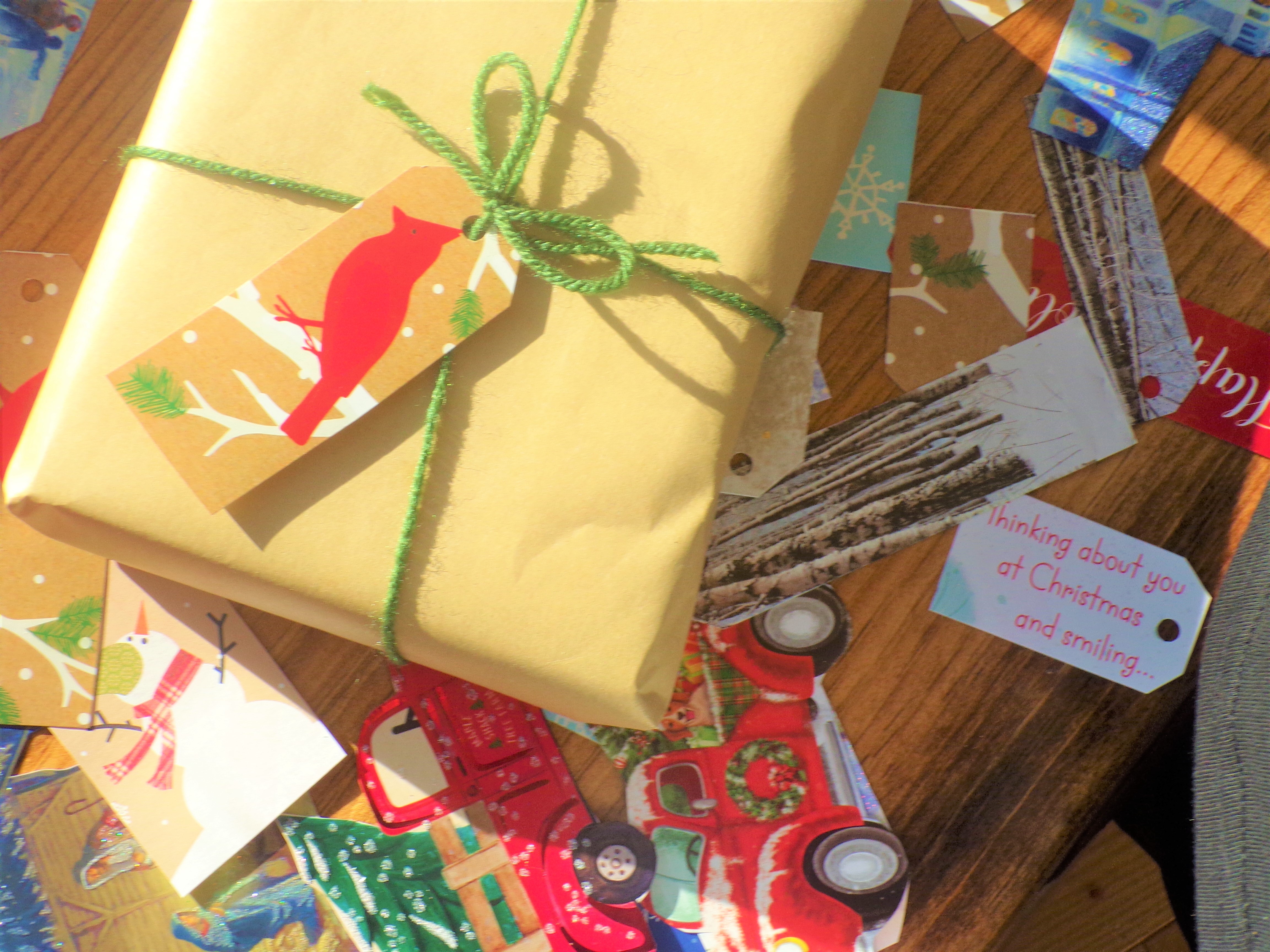 a handmade gift sits on top of handmade diy gift tags made from repurposed cards