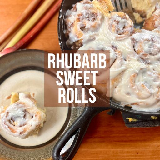 Rhubarb sweet roll on a plate with cast iron pan full of more sweet rolls in the background
